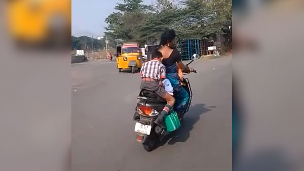 కదిలే స్కూటర్ మీద హోమ్ వర్క్ చేస్తున్న పిల్లాడు