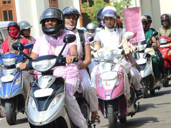 కదిలే స్కూటర్ మీద హోమ్ వర్క్ చేస్తున్న పిల్లాడు