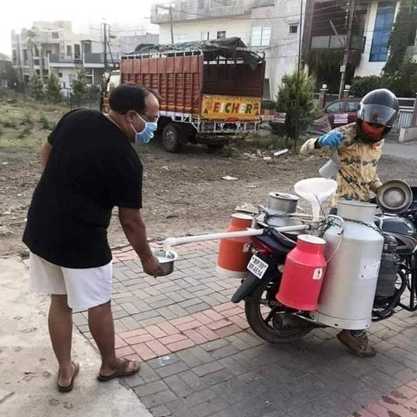 కరోనా ఎఫెక్ట్ : సామజిక దూరంతో పాలు పోస్తున్న పాల వ్యాపారి