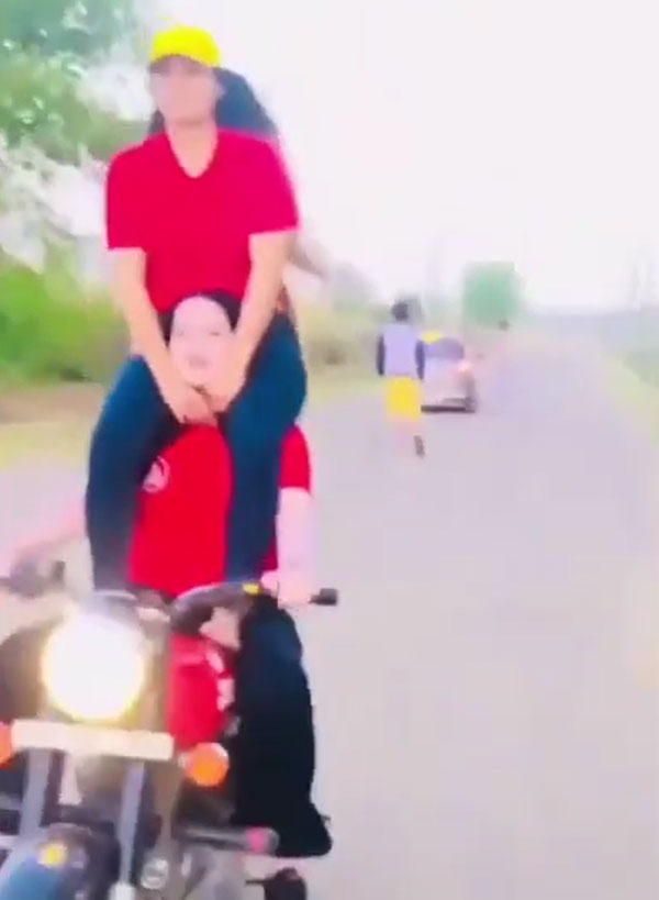ఒకరిపై ఒకరు కూర్చుని ప్రమాదకరమైన బైక్ స్టంట్స్ చేసిన యువతులు